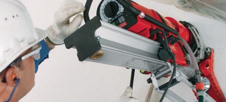 Hombre con casco utilizando herramienta eléctrica para trabajar en el techo.