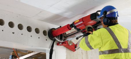 Trabajo de construcción con una máquina perforadora en una estructura de concreto.